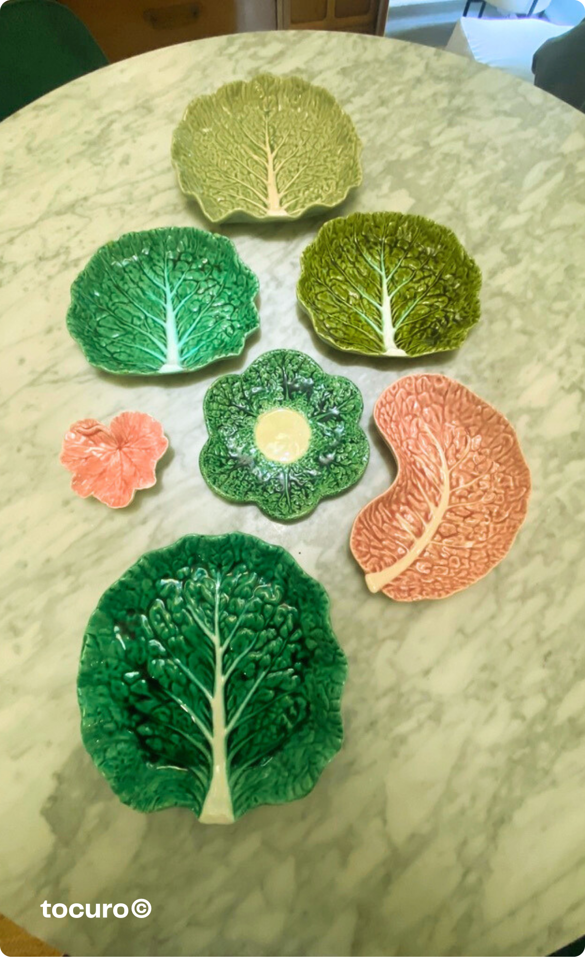 My Bordallo Pinheiro cabbage dish collection displayed together—what started as one impulse purchase grew into a family of Portuguese pottery in greens, pinks, and corals that now anchors my ceramics collection